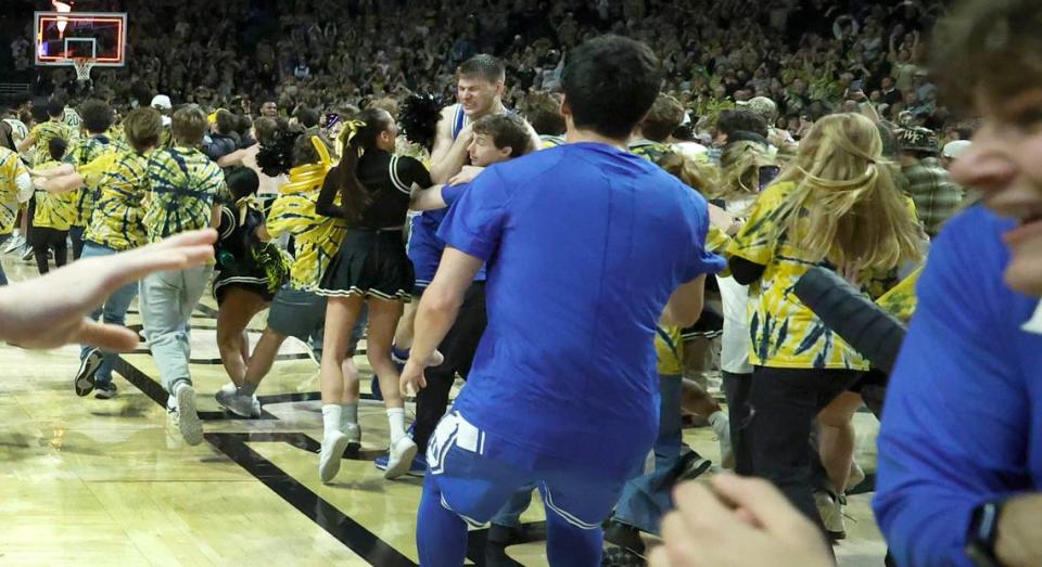 Duke’s Kyle Filipowski (30) is helped off the floor as students rush the court after Wake Forest’s 83-79 victory over Duke at Lawrence Joel Veterans Memorial Coliseum in Winston-Salem, N.C., Saturday, Feb. 24, 2024.