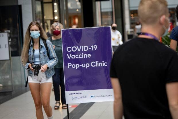 Health-care providers with Unity Health Toronto administer the Pfizer-BioNTech COVID-19 vaccine at a one-day pop-up clinic in the Eaton Centre mall. (Evan Mitsui/CBC - image credit)