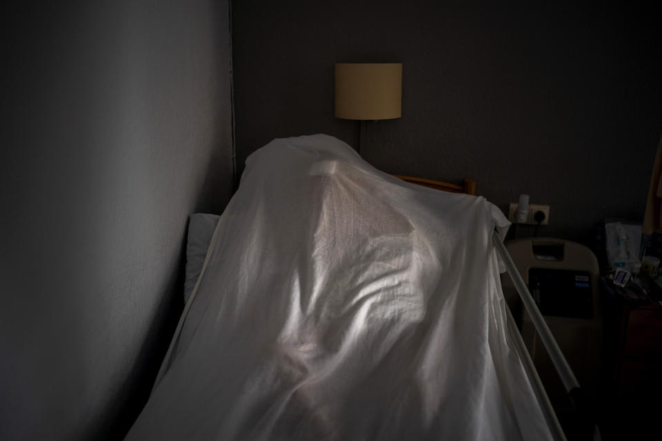The body of an elderly person who died of COVID-19 is covered with a sheet on her bed in a nursing home in Barcelona, Spain, Friday, Nov. 13, 2020. Virus cases among the elderly are again on the rise across Europe, causing havoc and rising death tolls in nursing homes despite the lessons of a tragic spring. Authorities are in a race to save lives as they wait for crucial announcements on mass vaccinations. (AP Photo/Emilio Morenatti)