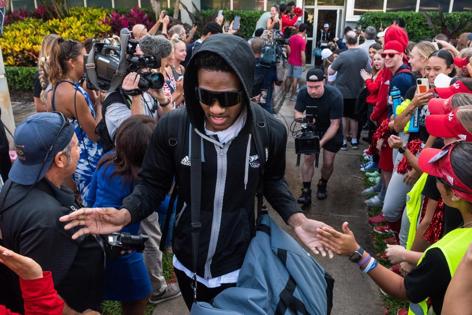 Florida Atlantic guard Brandon Weatherspoon hi-fives fans as he approaches the team buses at Baldwin Arena on Wednesday, March 29, 2023, in Boca Raton, FL. On Wednesday morning, the FAU men's basketball team departed for Houston, Texas, where they will play against San Diego State in the NCAA Tournament semi-final on Saturday.