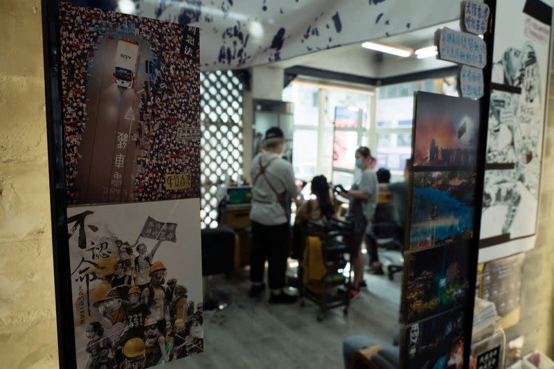 Pro-democracy signs and postcards are seen on a mirror at Hair Guy Salon, in Hong Kong