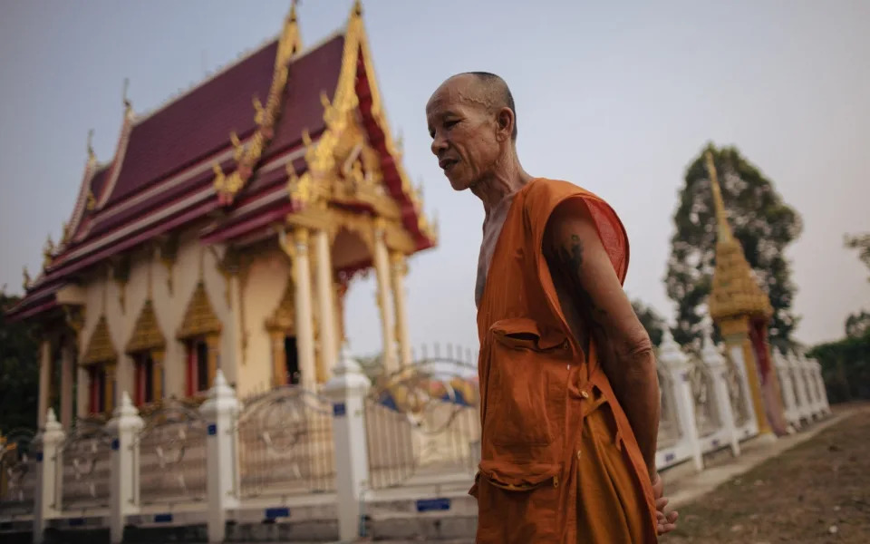Buddhist monk Prasert Sriwauria, 60, walks past Wat Ban Nong Phue Noi temple - Jack Taylor