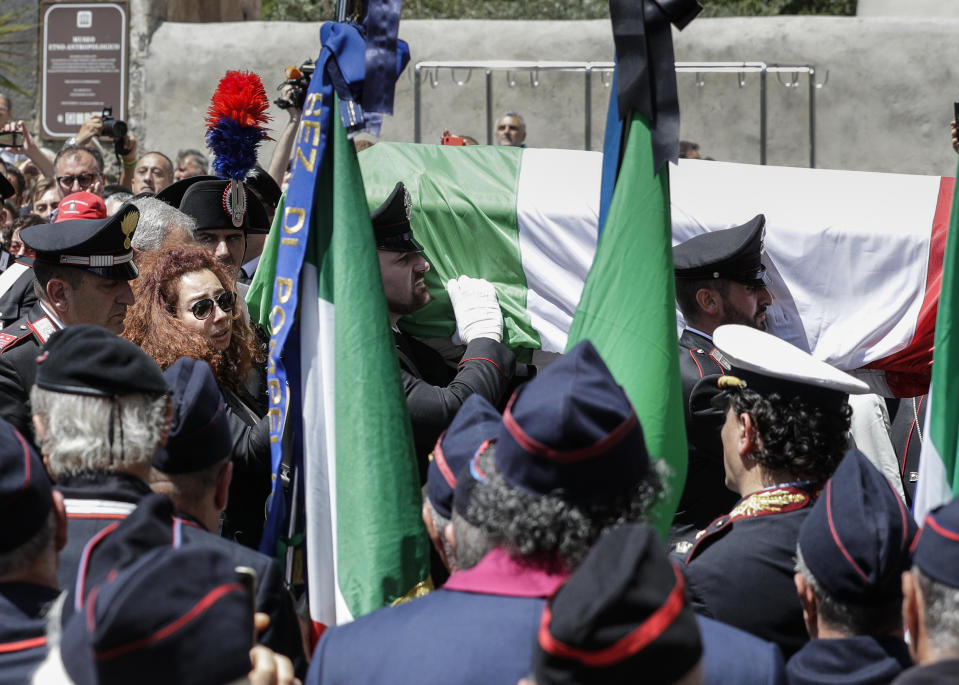 Carabinieri officer Mario Cerciello Rega's wife, Rosa Maria, left, follows the coffin containing the body of her husband during his funeral in his hometown of Somma Vesuviana, near Naples, southern Italy, Monday, July 29, 2019. Two American teenagers were jailed in Rome on Saturday as authorities investigate their alleged roles in the fatal stabbing of the Italian police officer on a street near their hotel. (AP Photo/Andrew Medichini)