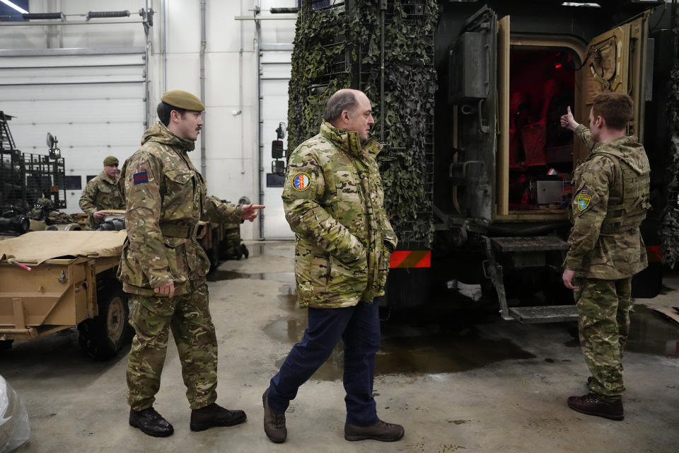 Britain's Defence Secretary Ben Wallace, centre, walks past Britain's military vehicles during his visit to the Tapa Military Camp, in Estonia, Thursday, Jan. 19, 2023. Wallace said his country would send at least three batteries of AS-90 artillery, armoured vehicles, thousands of rounds of ammunition and 600 Brimstone missiles, as well as the squadron of Challenger 2 tanks. (AP Photo/Pavel Golovkin)