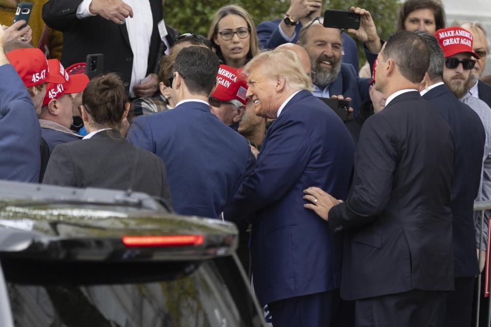 ormer President Donald Trump greets supporters as he arrives at the New Hampshire Statehouse, in Concord, N.H.,  to sign papers to get on the Republican presidential primary ballot on Monday.  