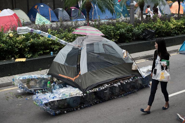 A woman walks past a tank made out of an umbrella, a tent and used plastic bottles in the Admiralty district of Hong Kong on October 24, 2014