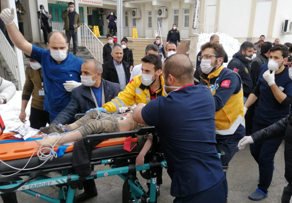 Medics and rescue workers carry a wounded boy to an ambulance after an earthquake hit villages in Baskale town in Van province, Turkey, at the border with Iran, Sunday, Feb. 23, 2020. Turkish Interior Minister Suleyman Soylu said numerous people have been killed and several others wounded in Sunday's quake.(DHA via AP)