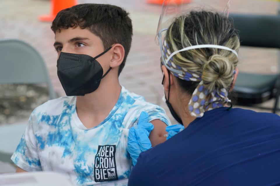Andres Veloso, 12, gets the first dose of the Pfizer COVID-19 vaccine in Miami. Florida is reporting a surge of COVID-19 cases caused by the highly contagious delta variant.