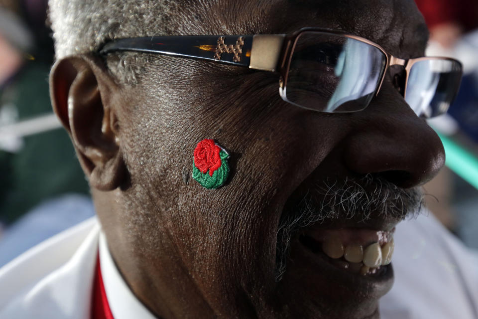 O.T. Triplett, who has worked the Pasadena Tournament of Roses since 1989, smiles while wearing a rose sticker before the start in the 124th Rose Parade in Pasadena, Calif., Tuesday, Jan. 1, 2013. (AP Photo/Patrick T. Fallon)