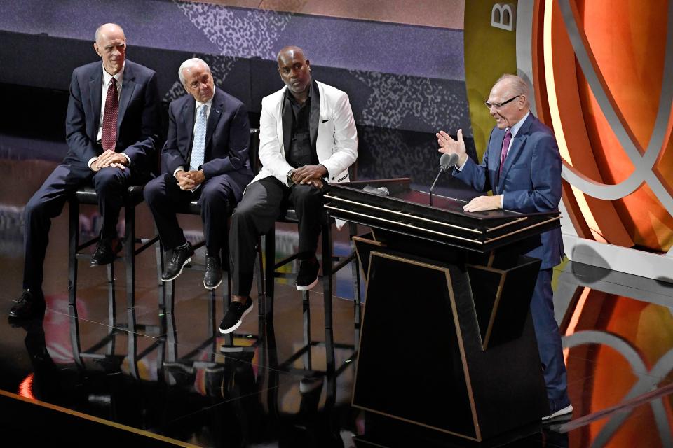 George Karl speaks during his enshrinement at the Basketball Hall of Fame as presenters Bobby Jones, Roy Williams and Gary Payton, from left, listen Saturday, Sept. 10, 2022, in Springfield, Mass. (AP Photo/Jessica Hill)