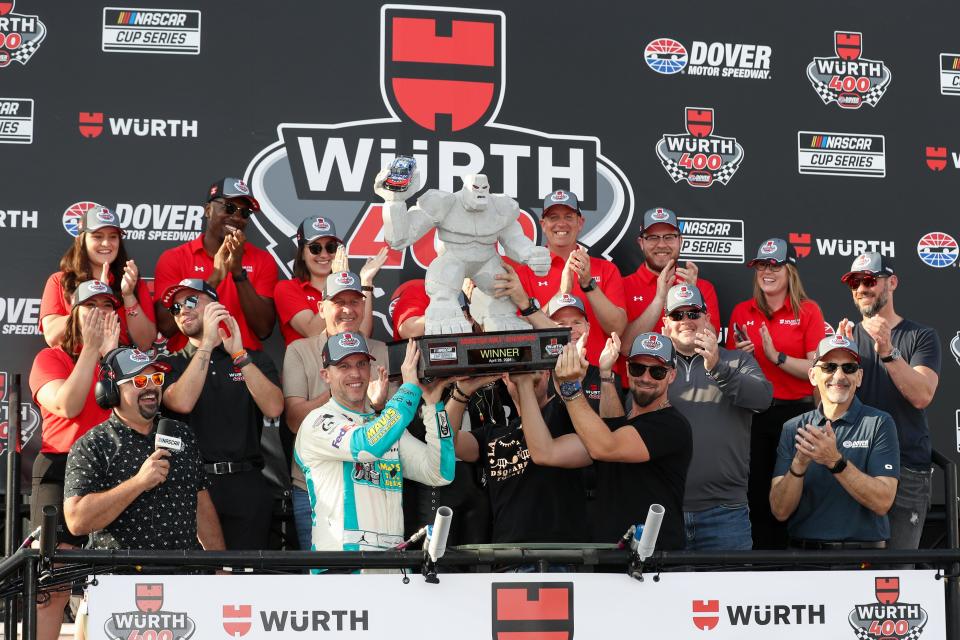 Denny Hamlin hoists one of NASCAR's coolest trophies, "Miles the Monster," after winning Dover.