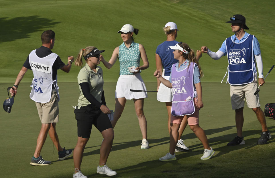 Michelle Wie West, Brooke M. Henderson, Anna Nordqvist and their caddies exchange fist-bumps on the 10th green during Round 1 of 2021 KPMG Women's PGA Championship at Atlanta Athletic Club in Johns Creek, Ga., Thursday, June 24, 2021. (Hyosub Shin/Atlanta Journal-Constitution via AP)