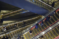 People wearing protective masks to help curb the spread of the coronavirus take usually crowded escalators at a shopping arcade in Tokyo Saturday, Jan. 9, 2021. The Japanese capital confirmed more than 2200 new coronavirus cases on Saturday. Japanese Prime Minister Yoshihide Suga declared a state of emergency last Thursday for Tokyo and three other prefectures to ramp up defenses against the spread of the coronavirus. (AP Photo/Eugene Hoshiko)