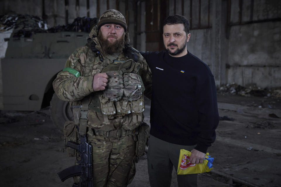 In this photo provided by the Ukrainian Presidential Press Office, Ukrainian president Volodymyr Zelenskyy and a soldier pose for a photo after an awarding ceremony at a position near Bakhmut, Donetsk region, Ukraine, Wednesday, March 22, 2023. (Ukrainian Presidential Press Office via AP)