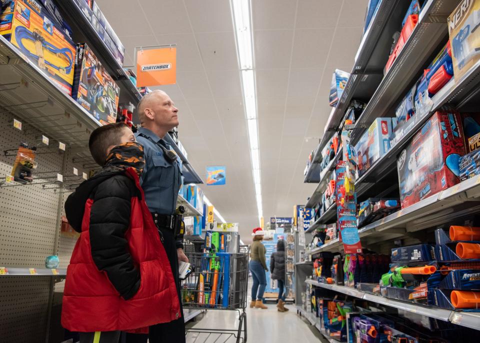 Nico Myers, 8, of Doylestown and Doylestown Township Police Ofc. Don Lawson look over a selection of Nerf guns during Plumstead Township Police Department's 5th annual Shop with a Cop event at Walmart in Hilltown Township on Tuesday, December 8, 2021. Funded by community donations, the program paired law enforcement officers from 11 local departments with more than 100 kids to help them shop for presents for themselves and their families.