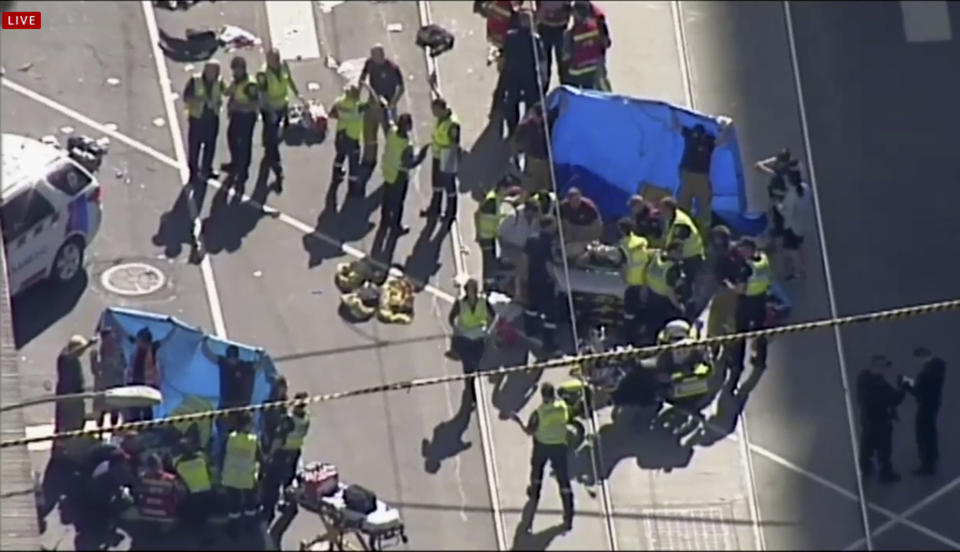 <em>Emergency medical workers rushed to help victims struck by the vehicle (Australian Broadcast Corp/AP)</em>