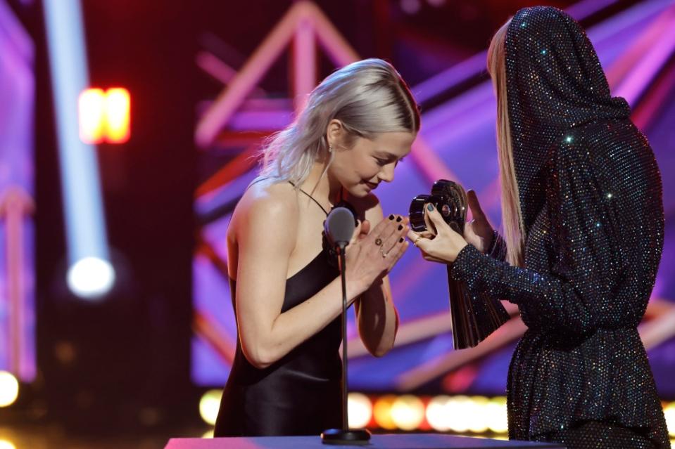 LOS ANGELES, CALIFORNIA - MARCH 27: (FOR EDITORIAL USE ONLY) (L-R) Phoebe Bridgers presents the iHeartRadio Innovator Award to honoree Taylor Swift onstage during the 2023 iHeartRadio Music Awards at Dolby Theatre in Los Angeles, California on March 27, 2023. Broadcasted live on FOX. (Photo by Kevin Winter/Getty Images for iHeartRadio)