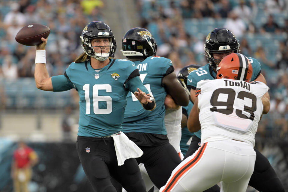 Jacksonville Jaguars quarterback Trevor Lawrence (16) throws a pass as Cleveland Browns defensive tackle Tommy Togiai (93) tries to stop him during the first half of an NFL preseason football game, Friday, Aug. 12, 2022, in Jacksonville, Fla. (AP Photo/Phelan M. Ebenhack)