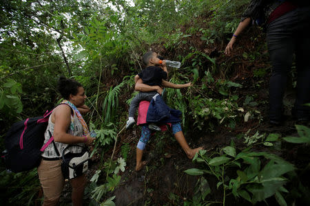 Honduran migrants hike in the forest after crossing the Lempa river, in the border line between Honduras and Guatemala to join a caravan trying to reach the U.S, in Guatemala October 17, 2018. REUTERS/Jorge Cabrera