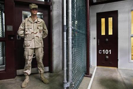 In this photo, reviewed by the U.S. military, a Guantanamo guard stands inside a doorway at Camp 6 detention facility at Guantanamo Bay U.S. Naval Base, Cuba, May 31, 2009. REUTERS/Brennan Linsley/Pool