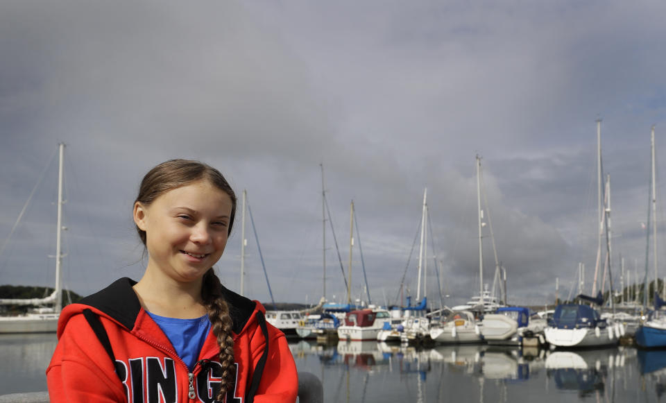 Greta Thunberg poses for a picture in the Marina where the boat Malizia is moored in Plymouth, England Tuesday, Aug. 13, 2019. Greta Thunberg, the 16-year-old climate change activist who has inspired student protests around the world, is heading to the United States this week - in a sailboat. (AP Photo/Kirsty Wigglesworth)