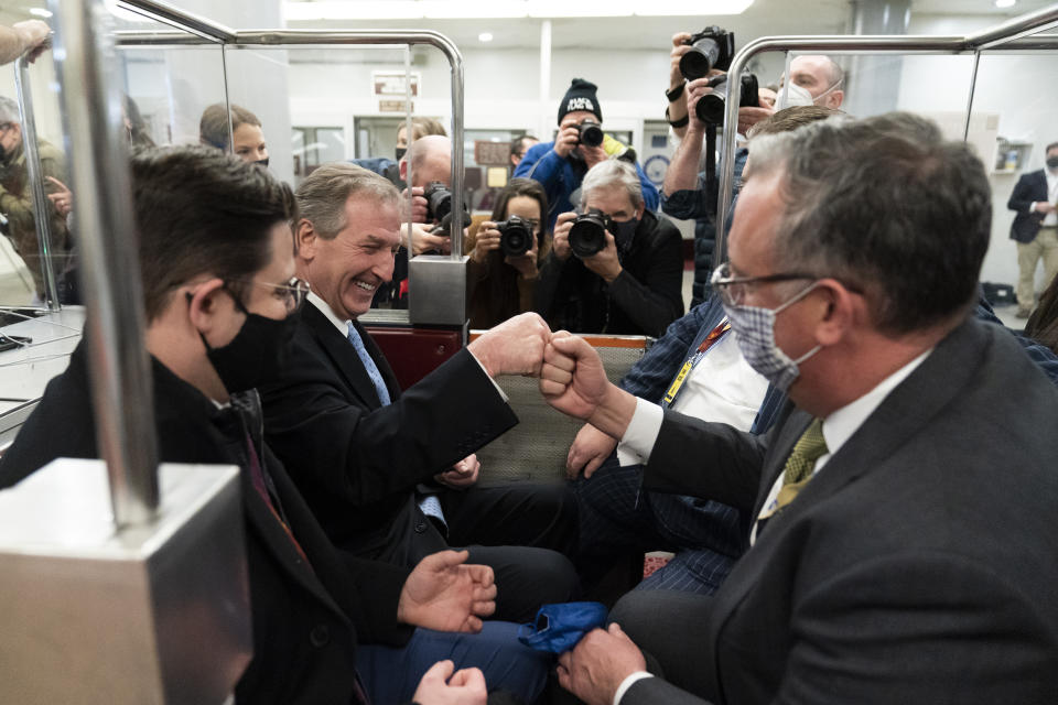 Michael van der Veen, second from left an attorney for former President Donald Trump, fist bumps a colleague as the depart on the Senate Subway, on Capitol Hill after the Senate acquitted Trump in his second impeachment trial in the Senate at the U.S. Capitol in Washington, Saturday, Feb. 13, 2021. Trump was accused of inciting the Jan. 6 attack on the U.S. Capitol, and the acquittal gives him a historic second victory in the court of impeachment. (AP Photo/Alex Brandon)