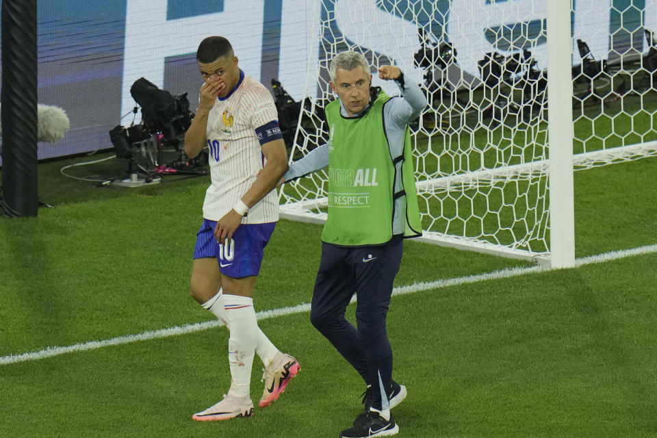 Kylian Mbappe of France is helped off the pitch after suffering an injury during a Group D match between Austria and France at the Euro 2024 soccer tournament in Duesseldorf, Germany, Monday, June 17, 2024. (AP Photo/Hassan Ammar)