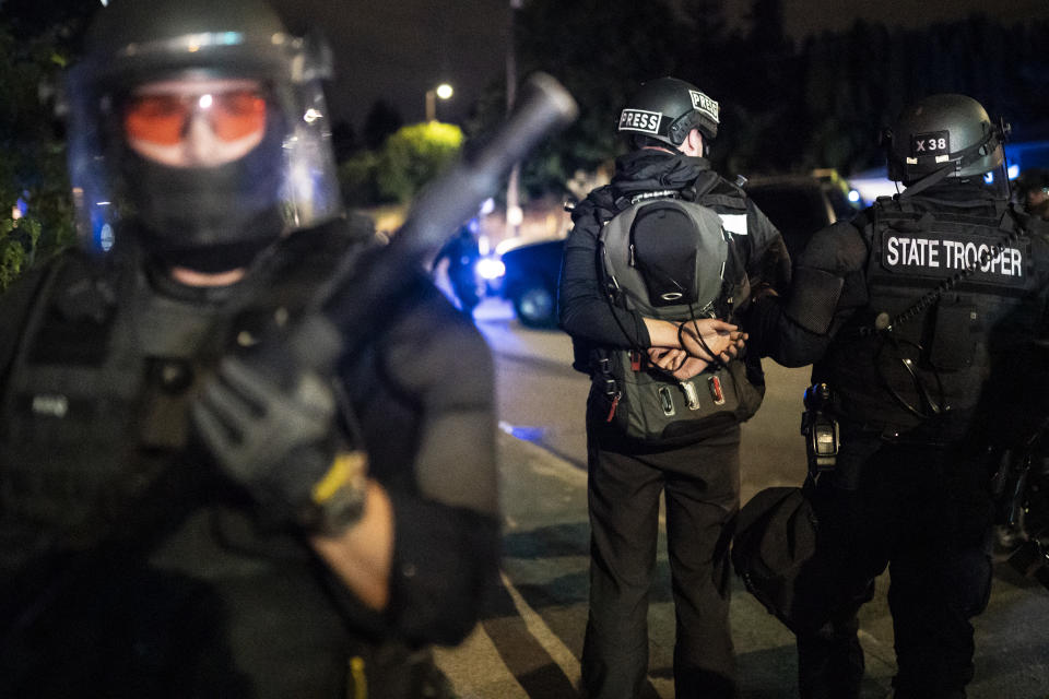 PORTLAND, OR - AUGUST 30: An Oregon State Trooper arrests journalist Gabriel Trumbly during a crowd dispersal near the Portland east police precinct on August 30, 2020 in Portland, Oregon. City leaders asked for calm and time to conduct an investigation after a man was shot and killed near a pro-Trump rally on Saturday. (Photo by Nathan Howard/Getty Images)