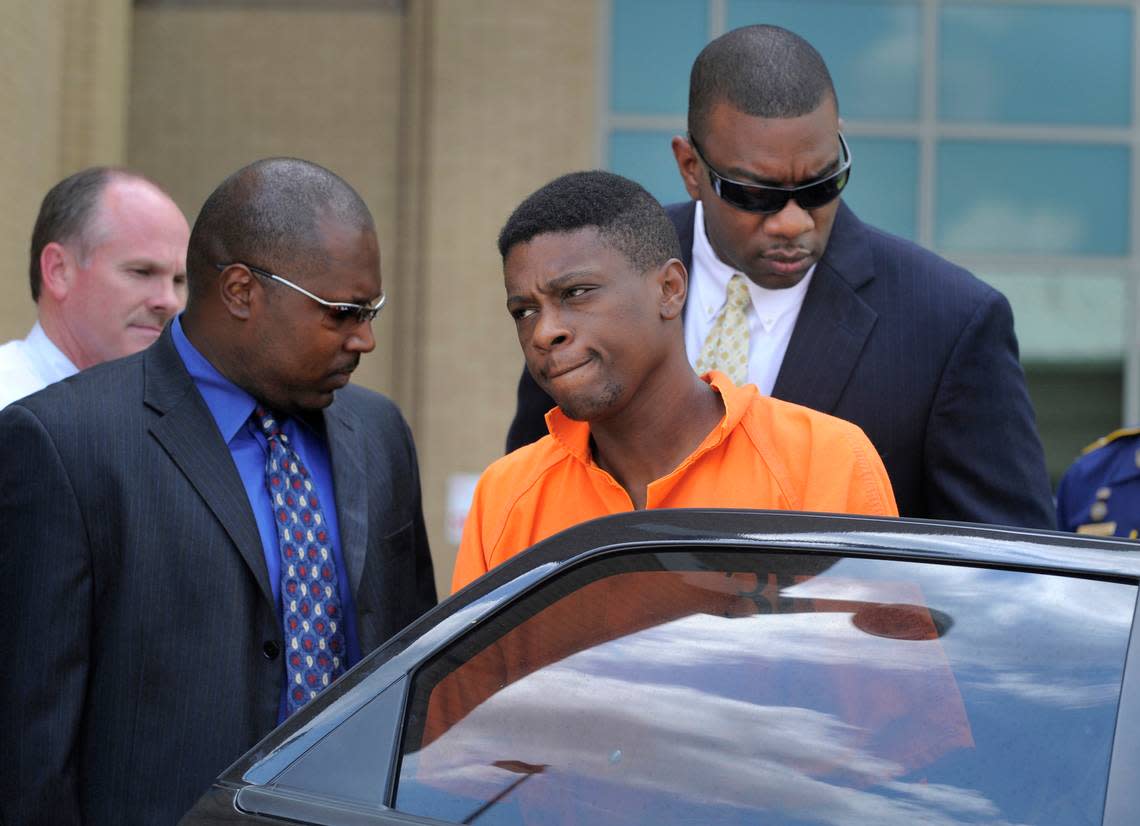 Rapper Lil’ Boosie, third from left in orange jump suit, is placed in a car by Baton Rouge police on Friday, June 18, 2010.