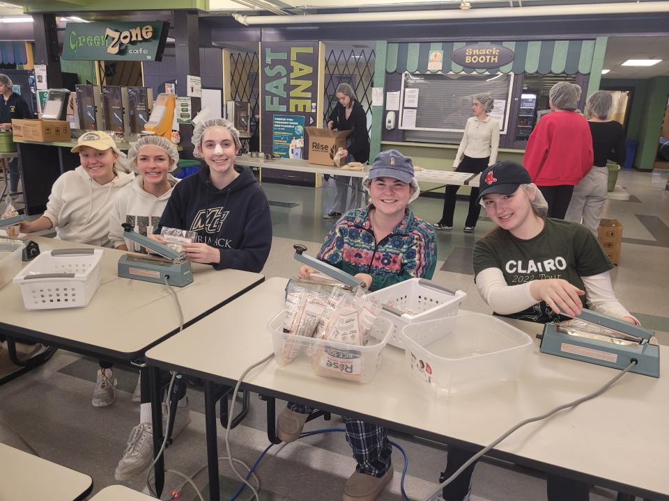 From left, Claire Hohn, Lily Doucette, Emily Balzotti, Dylan Kaplan and Sidney Babers were among more than 70 volunteers from Nashoba Regional and Littleton high schools who helped package 18,000 meals at Saturday morning at the same time the EMT marathon was unfolding.