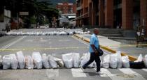A pedestrian walks past a barricade during a strike called to protest against Venezuelan President Nicolas Maduro's government in Caracas, Venezuela July 27, 2017 . REUTERS/Andres Martinez Casares