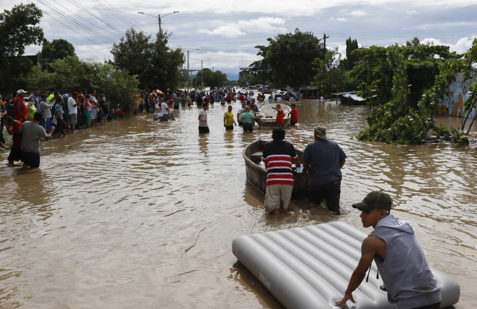 Residents use boats and rafts to navigate a flooded road in the aftermath of Hurricane Eta in Jerusalen, Honduras, Thursday, Nov. 5, 2020. The storm that hit Nicaragua as a Category 4 hurricane on Tuesday had become more of a vast tropical rainstorm, but it was advancing so slowly and dumping so much rain that much of Central America remained on high alert. (AP Photo/Delmer Martinez)