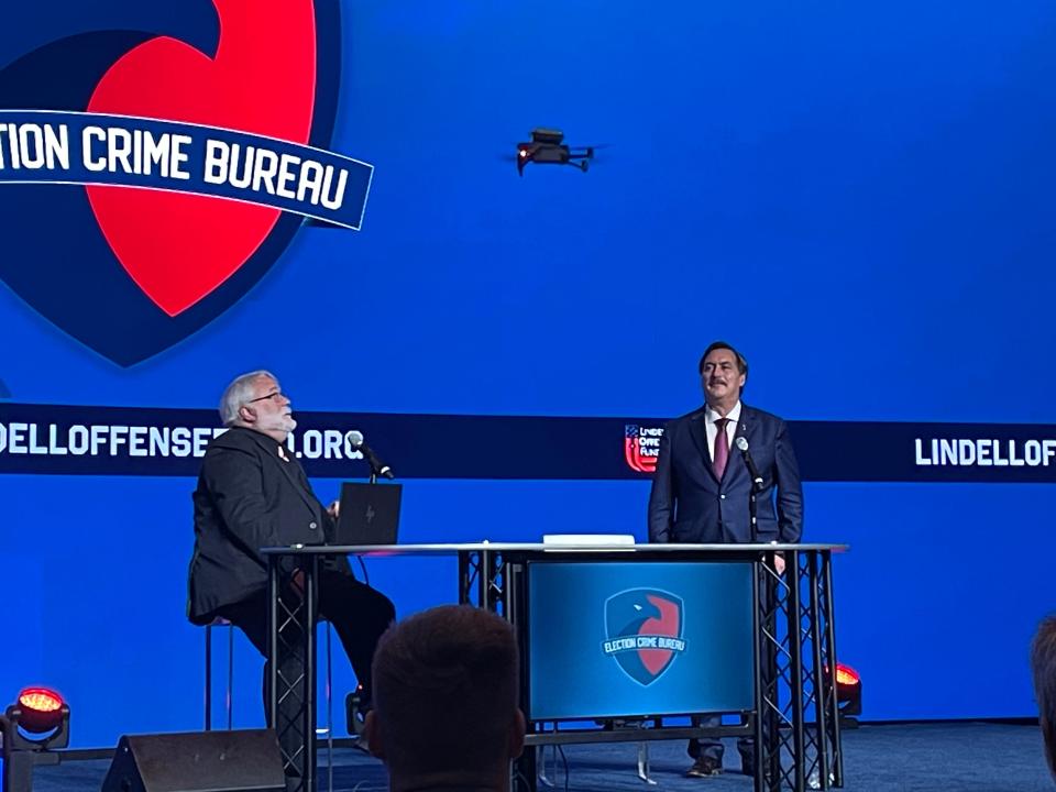 Mike Lindell and Jeff O'Donnell, a 2020 election denier, watch as a drone flies towards them, mounted with a Wireless Monitoring Device capable of detecting Wi-Fi connections at polling places during Lindell's Election Crime Bureau Summit on Aug. 17 in Springfield, MO.