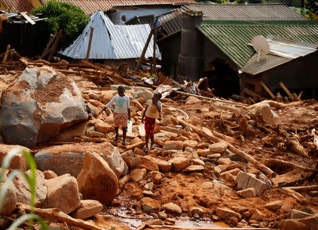 Children carry drinking water over debris created by Cyclone Idai at Peacock Growth Point in Chimanimani, on the border with Mozambique, Zimbabwe March 22, 2019. REUTERS/Philimon Bulawayo