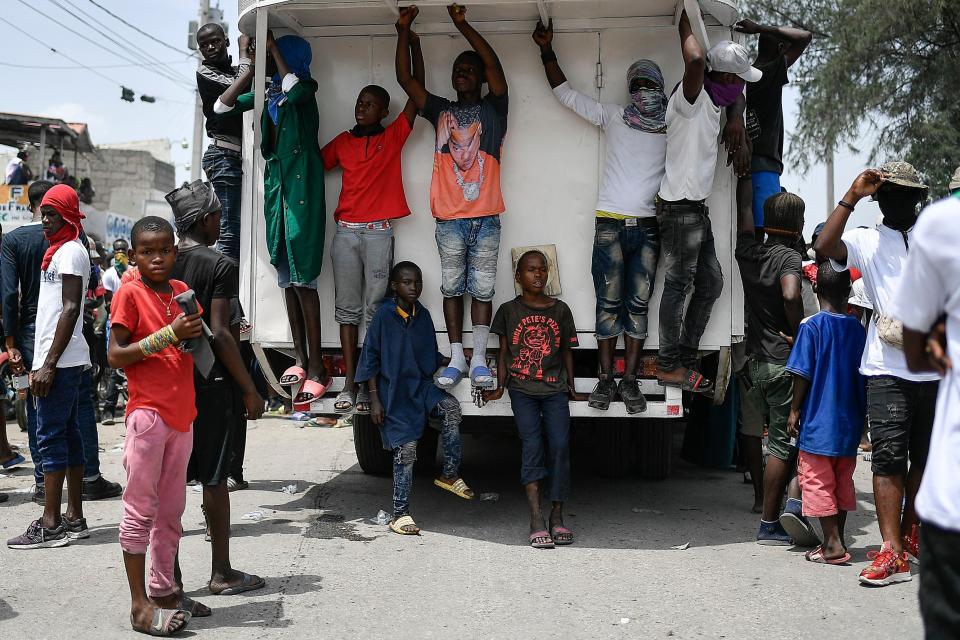 FILE - Youths and members of the gang led by Jimmy Cherizier, alias Barbecue, a former police officer who heads a gang coalition hang out during a march to demand justice for slain Haitian President Jovenel Moise, in the La Saline neighborhood of Port-au-Prince, Haiti, July 26, 2021. (AP Photo/Matias Delacroix, File)