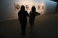 Two women visit a 19th and 20th-century American and European minimalist and conceptual masterpieces show at the Tehran Museum of Contemporary Art in Tehran, Iran, Tuesday, Aug. 2, 2022. Some of the world’s most prized works of contemporary Western art have been unveiled for the first time in decades — in Tehran. (AP Photo/Vahid Salemi)