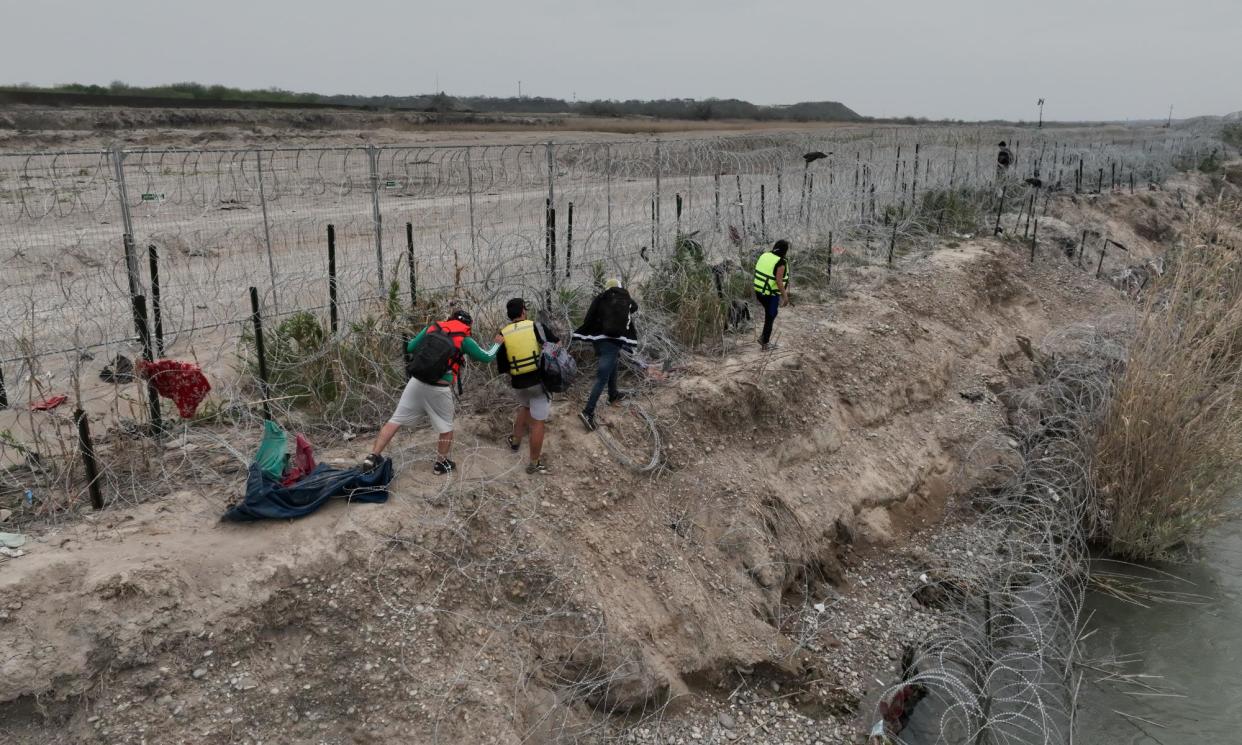 <span>Migrants at border crossing in Eagle Pass, Texas, ahead of the anticipated visit by Donald Trump on Thursday.</span><span>Photograph: Anadolu/Getty Images</span>