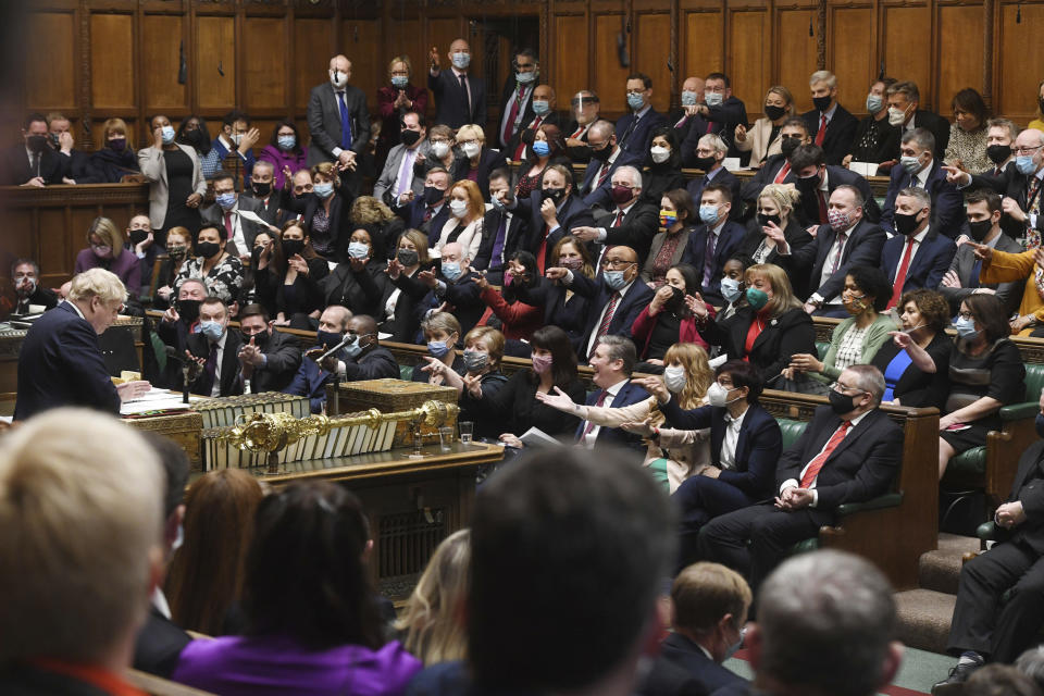 In this photo provided by UK Parliament, Britain's Prime Minister Boris Johnson speaks as members of the opposition party gesture, during Prime Minister's Questions in the House of Commons, in London, Wednesday, Jan. 12, 2022. Johnson has apologized for attending a garden party during Britain’s first coronavirus lockdown, but brushed aside opposition demands that he resign for breaching the rules his own government had imposed on the nation. The apology Wednesday stopped short of admitting wrongdoing. It was Johnson’s attempt to assuage a tide of anger from the public and politicians after repeated accusations he and his staff flouted pandemic restrictions by socializing when it was banned. (UK Parliament/Jessica Taylor via AP)