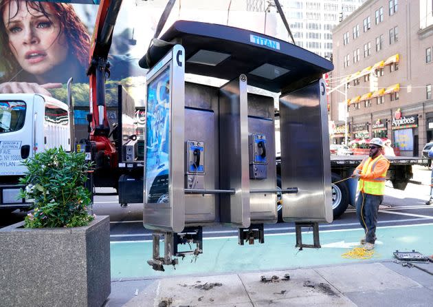 Workers remove the final New York City payphone near Seventh Avenue and 50th Street in Midtown Manhattan on Monday. (Photo: TIMOTHY A. CLARY via Getty Images)