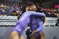 Simone Biles of the United States, right and gold medal, is hugged by Sunisa Lee of the United States, left and silver medal, after the floor exercise in the women's apparatus finals at the Gymnastics World Championships in Stuttgart, Germany, Sunday, Oct. 13, 2019. (AP Photo/Matthias Schrader)