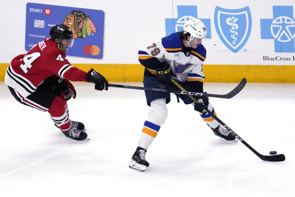 St. Louis Blues left wing Sammy Blais, right, controls the puck past Chicago Blackhawks defenseman Wyatt Kaiser during the second period of an NHL hockey game in Chicago, Sunday, Nov. 26, 2023. (AP Photo/Nam Y. Huh)