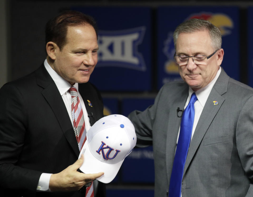 Les Miles, left, is introduced as Kansas football coach by athletic director Jeff Long, right, during a news conference in Lawrence, Kan., Sunday, Nov. 18, 2018. (AP Photo/Orlin Wagner)