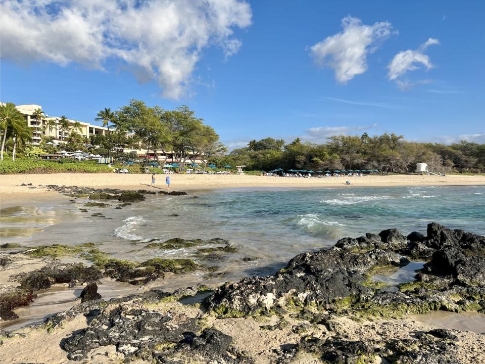 A view of the north end of Hapuna Beach, with water, sand, and tide pools