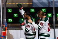 Minnesota Wild's Matt Dumba (24) raises his fist during the national anthems as Jonas Brodin (25) puts his hand on his shoulder before the team's hockey playoff game against the Vancouver Canucks in Edmonton, Alberta, Tuesday, Aug. 4, 2020. (Codie McLachlan/The Canadian Press via AP)
