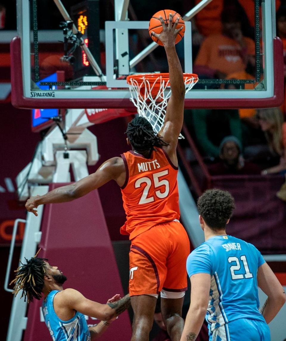 Virginia Tech’s Justyn Mutts (25) goes for a dunk over North Carolina’s R.J. Davis (4) and Will Shaver (21) during the second half on Sunday, December 4, 2022 at Cassell Coliseum in Blacksburg, Va. Mutts lead all scores with 27 points and Virginia Tech to an 80-72 victory.