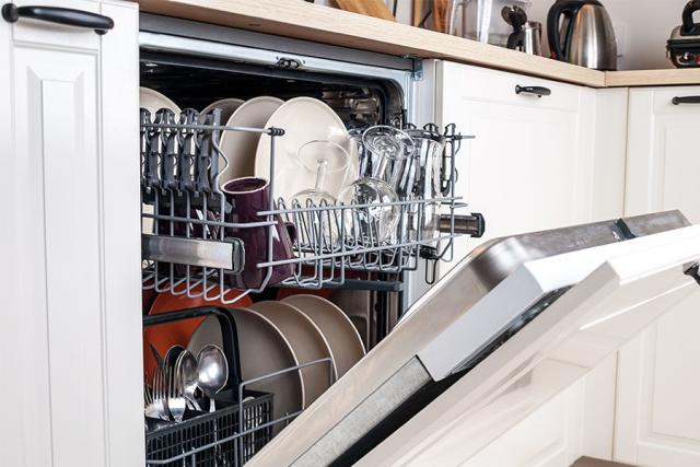 Woman Loading Washing Machine In Kitchen High-Res Stock Photo - Getty Images