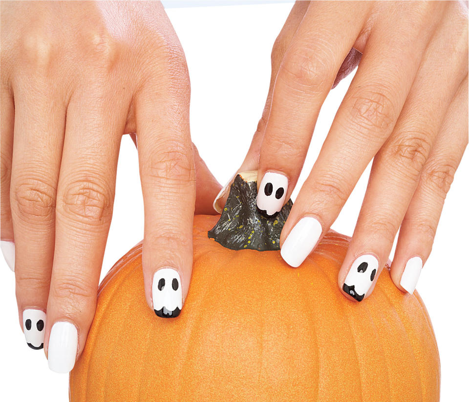 Nails on a pumpking painted with a ghost Halloween nail designs