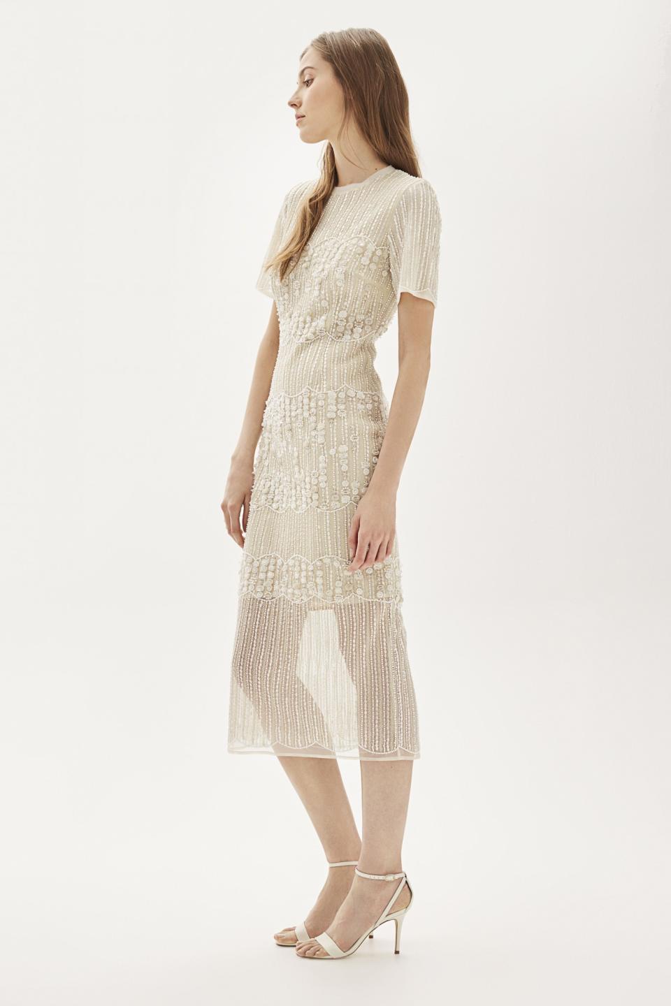 A model wears an embellished pencil midi dress from the Topshop Bride collection