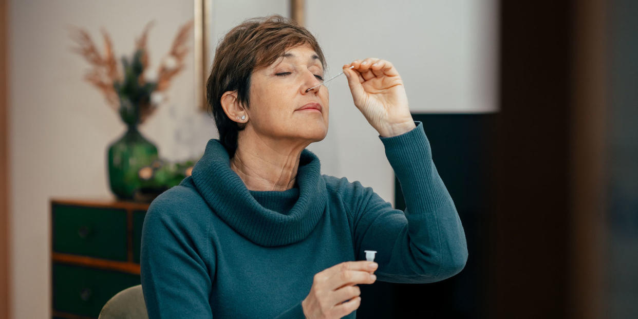 Woman using a Covid test on herself (Basilico Studio Stock / Getty Images)