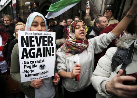 A girl holds a placard as she takes part in a counter-demonstrations against a rally by supporters of the Pegida movement in Newcastle, northern England, February 28, 2015. REUTERS/Peter Nicholls